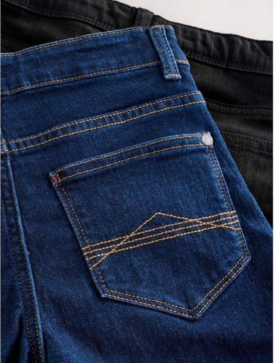 Achterkant van een blauwe spijkerbroek met gedetailleerde stiksels op de zak.