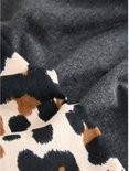 Close-up van de stof van een donkergrijs T-shirt naast stof met luipaardprint.