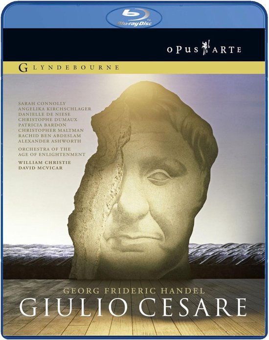 Gegraveerd buste van Giulio Cesare op een stenen fragment, met de titel van de opera en cast. Blu-ray hoes.