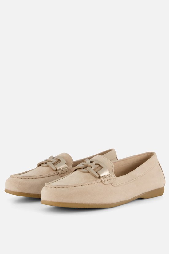 Een paar licht beige suède instappers met gouden schakeldetail en gestikte rand.