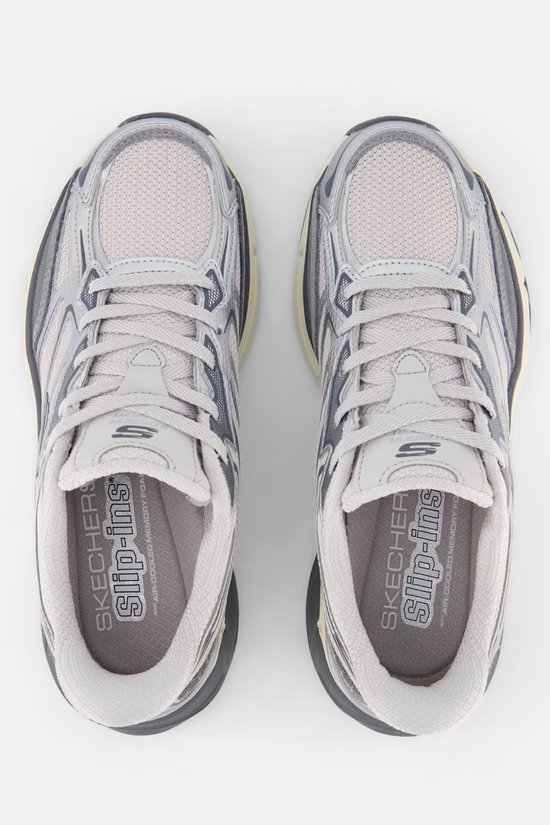 Zicht van bovenaf op zilverkleurige Skechers sneakers met mesh en metallic details.