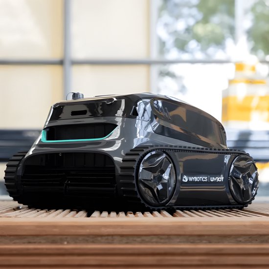 Zwarte Wybot zwembadrobot met blauwe accenten, brede rupsbanden en glimmende wielen, staand op houten planken.