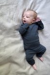 Baby in donkergrijs, geribd pyjamapakje.