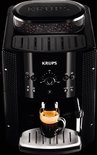 Zwarte Krups espressomachine met glas espresso met crema.