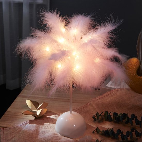 Lampe à plumes rose avec lumière blanc chaud, sur une table en bois avec du lin.