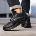 Zwarte werksneakers met veters, mesh panelen en een golvende, stevige zool.
