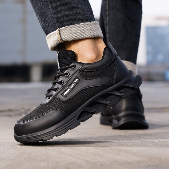 Zwarte werksneakers met veters, mesh panelen en een golvende, stevige zool.