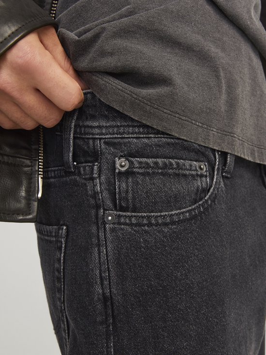 Detailopname van de zakken van een losse, zwarte jeans.