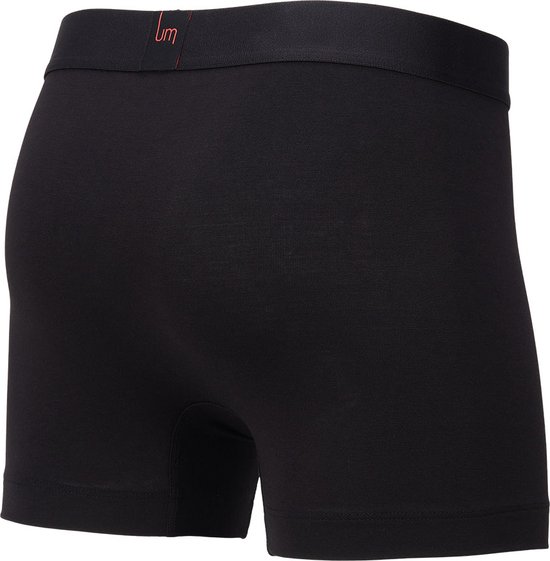Achterkant van een zwarte boxer met oranje label met 'um'. Brede tailleband.