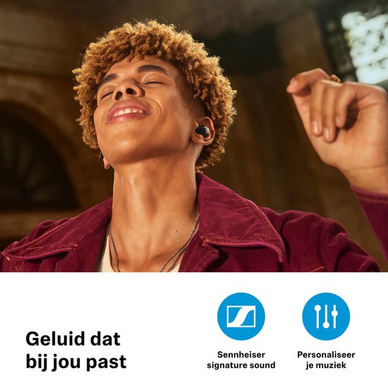 Man met kroeshaar en bordeaux jasje draagt zwarte oordopjes en geniet van muziek. Tekst: Geluid dat bij jou past.