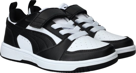 Een paar zwart-witte lage sneakers met witte veters en klittenbandsluitingen.