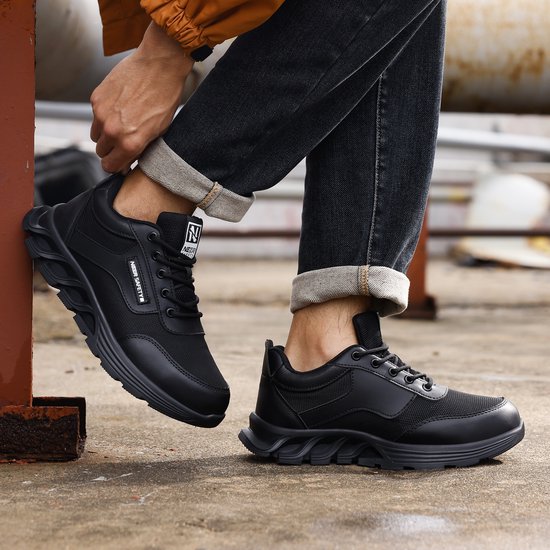 Zwarte lage werksneakers met veters, ademend mesh en robuuste zool. 'NEZR SAFETY' logo op de zijkant.