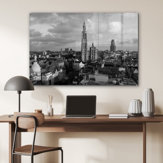 Zwart-wit stadsgezicht van Antwerpen met de kathedraal, hangend boven een bureau.