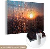 MuchoWow® Glasschilderij 30x20 cm - Schilderij acrylglas - Een nat raam met een wazig uitzicht op een zonsondergang - Foto op glas - Schilderijen