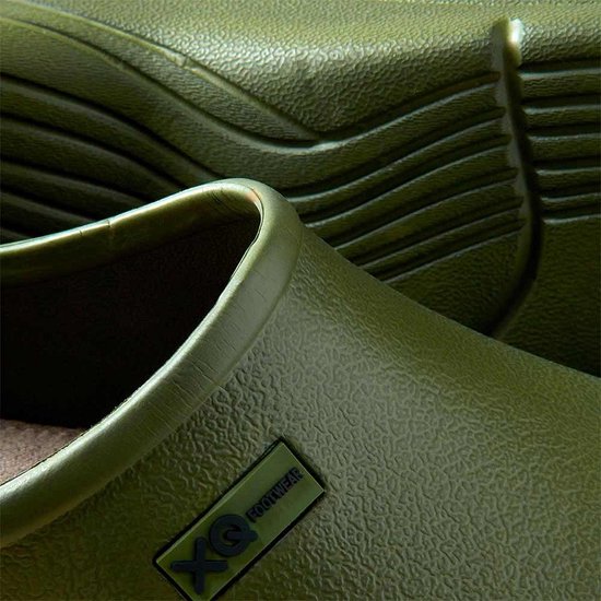 Close-up van de groene klomp met XQ Footwear logo en textuur.
