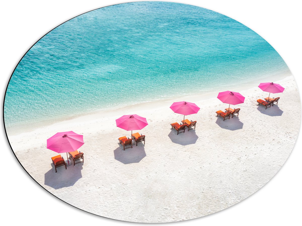 Dibond Ovaal - Ligbedden onder Roze Parasols op het Witte Strand bij Blauwe Oceaan - 80x60 cm Foto op Ovaal (Met Ophangsysteem)
