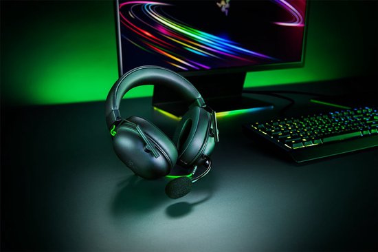 Zwarte Razer gaming headset op een donker bureau met groene achtergrondverlichting.