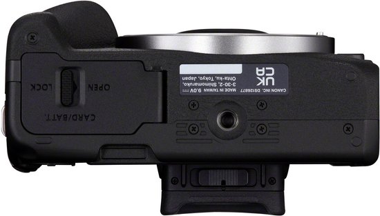 Bovenaanzicht van de zwarte Canon EOS R50 systeemcamera met open batterijvak.