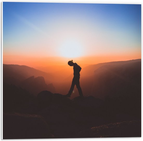 WallClassics - PVC Schuimplaat - Silhouet Persoon tussen de Bergen bij Zonsondergang - 50x50 cm Foto op PVC Schuimplaat (Met Ophangsysteem)