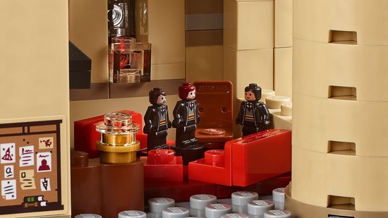 Lego Harry Potter 71043, drie leerlingen in Zweinstein-uniformen in een rode kamer met kasten en een poster.