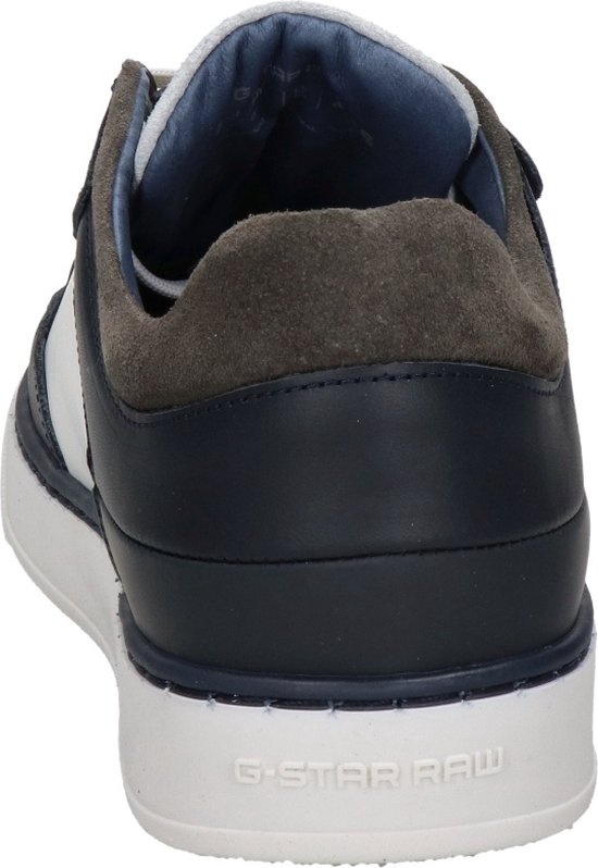 Achterkant van een witte sneaker met marineblauwe en bruine accenten. De zool is wit met 'G-STAR RAW' erop.
