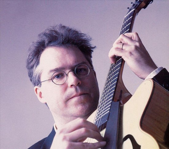 Bill Frisell, man met bril, grijze haren, speelt op een gitaar.