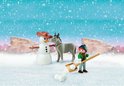 Playmobil Spirit winterscène met sneeuwpop, ezel en figuur die sneeuwballen werpt.