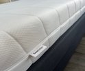 Wit matras met ritssluiting en EasyBedden label, close-up detail.