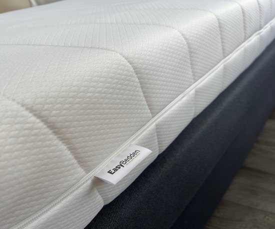 Wit matras met ritssluiting en EasyBedden label, close-up detail.