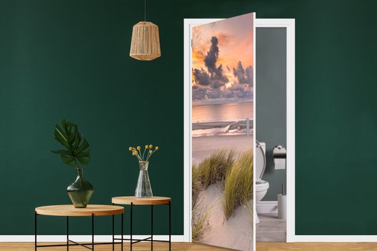 Deurposter met duinlandschap bij zonsondergang boven de zee.