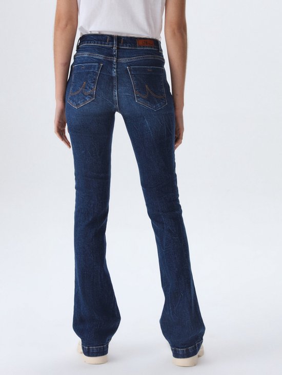 Model draagt een donkerblauwe flared jeans, de achterkant van LTB.