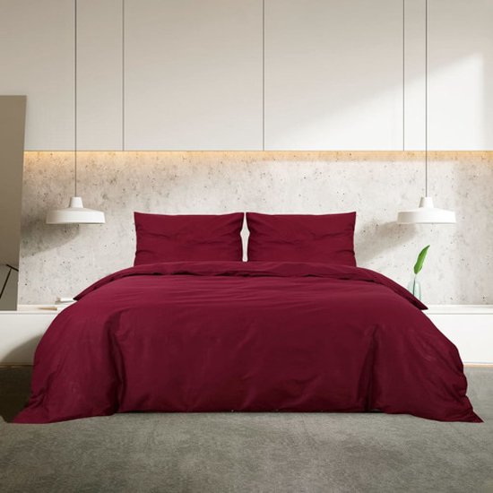 Ensemble de housses de couette en coton bordeaux sur un lit avec deux taies d'oreiller.