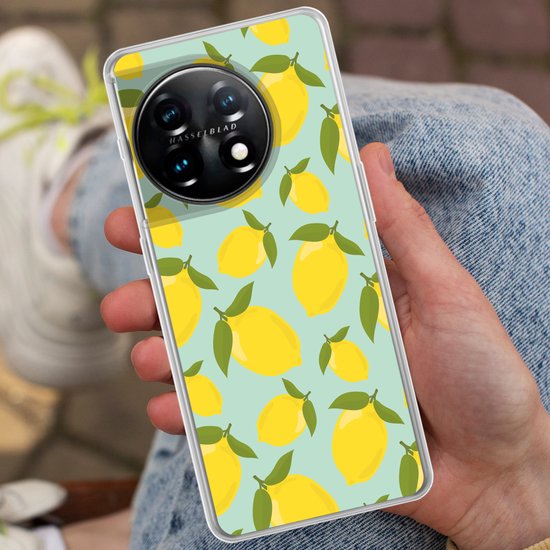 Une main tient une coque de téléphone à motif citron jaune sur fond bleu clair, assise en jean.