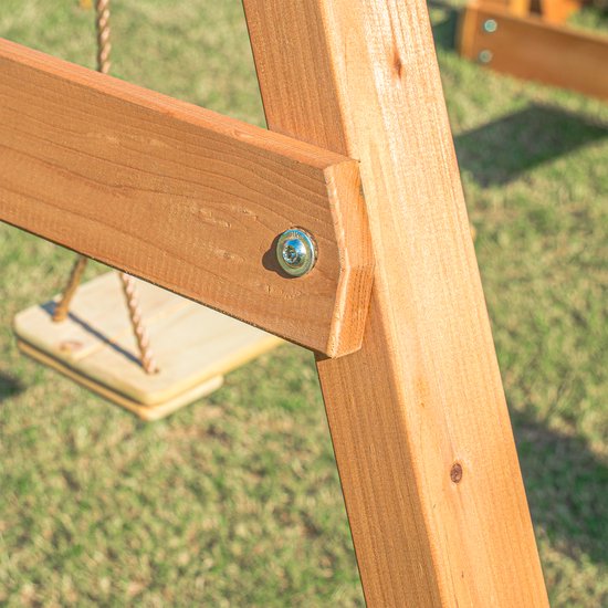 Detail van een houten schommel met touwen en een metalen bout.