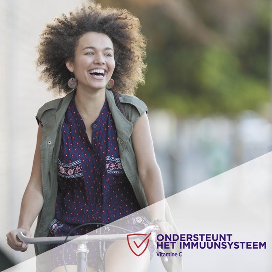 Vrolijke jonge vrouw met afro-kapsel op een fiets, lachend. Tekst: "Ondersteunt het immuunsysteem. Vitamine C".