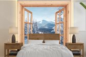 Behang - Fotobehang Doorkijk - Winterlandschap - Natuur - Berg - Bomen - Hout - Breedte 350 cm x hoogte 350 cm