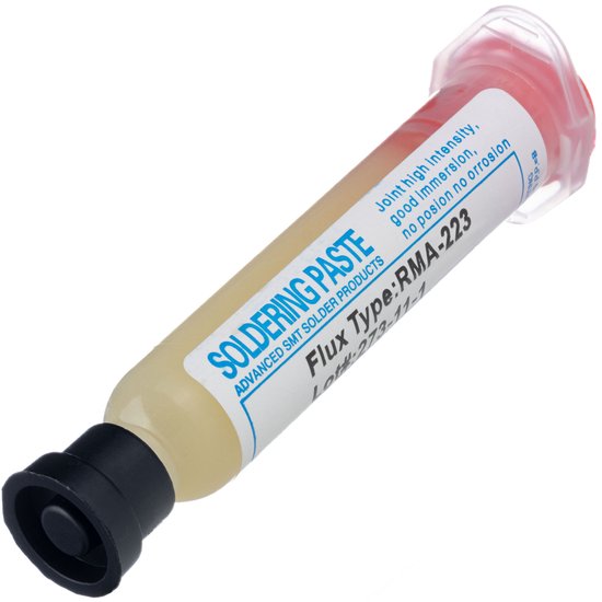 Spuit met RMA-223 soldeerflux, met een zwarte dop en rood afsluitdopje aan het uiteinde. Etiket is zichtbaar.