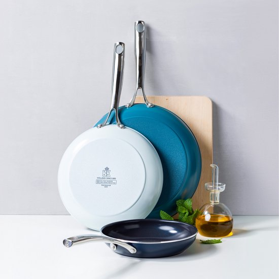 Twee koekenpannen, één lichtblauwe en één blauwe, met een kleinere zwarte pan op de voorgrond.