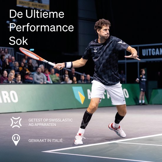 Joueur de tennis en action, portant des chaussettes de compression noires avec logo blanc. "La Chaussette de Performance Ultime". Testé sur appareils Swisslastic AG, fabriqué en Italie.