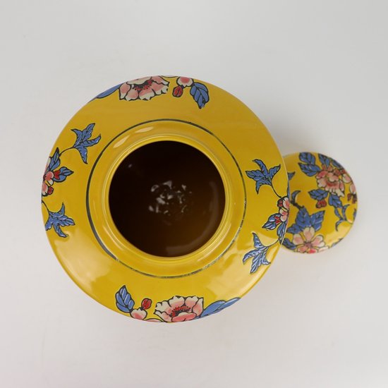 Bovenaanzicht van een gele gemberpot met deksel, versierd met bloemen en bladeren.