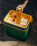 Hand plaatst een fles water in een koelbox met ijs, perziken en een waterdrop Ice Tea Peach doosje.