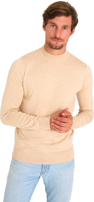Man met beige coltrui en lichte spijkerbroek, van voren gezien.
