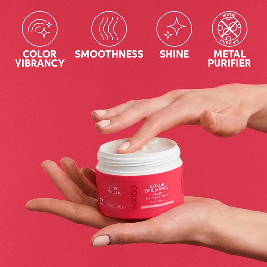 Vrouwenhanden houden een rode pot met Wella Invigo Color Brilliance masker vast. Iconen tonen kleurglans, gladheid, glans, en metaalzuivering.