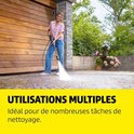 Vrouw gebruikt Karcher hogedrukreiniger op terras bij houten garagedeur, "Utilisations Multiples" voor diverse schoonmaaktaken.