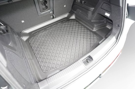 Zwarte kofferbakmat met ruitvormig profiel, passend in een auto.