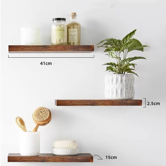 Drie zwevende donkerbruine houten planken aan een witte muur met decoraties.