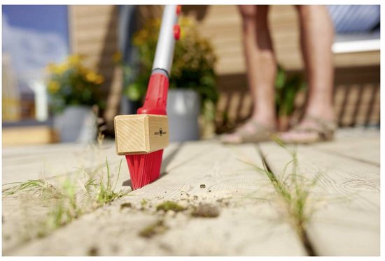 Voegenschraper met houten kop en rode borstelharen reinigt tussen houten planken.