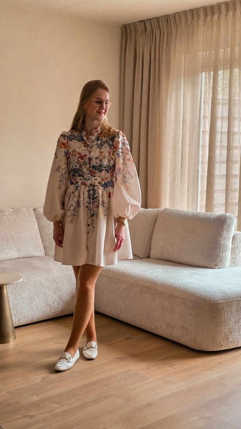 Robe pour femme à imprimé floral, beige avec des fleurs rouges, bleues et jaunes, manches ballon longues, ceinture et fermeture à nœud.