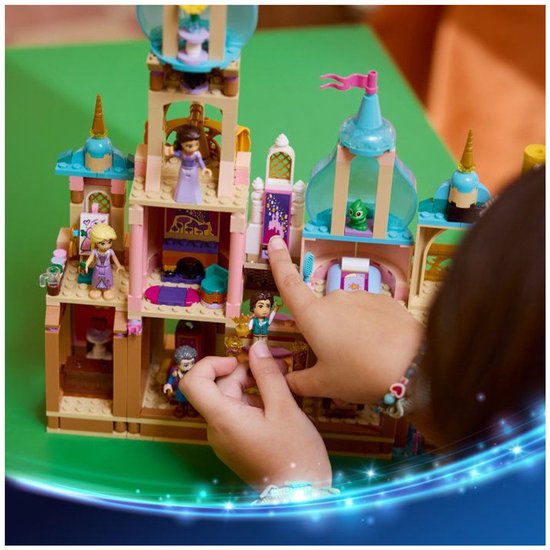 Kind speelt met LEGO Disney Rapunzel's Kasteel, met zes figuren en een boot.