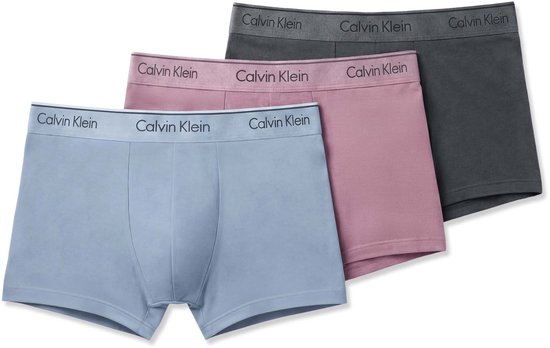 Drie Calvin Klein boxershorts in blauw, roze en grijs, met grijze taillebanden.